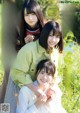 A group of young women standing next to each other in a field.