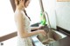 A woman is washing dishes in a kitchen sink.