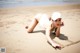 A woman laying on the sand on a beach.