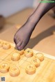 A person playing a game of chinese checkers on a wooden board.