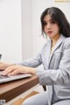 A woman sitting at a desk using a laptop computer.