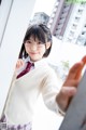 A young woman wearing glasses and a white cardigan.