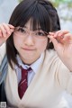 A young woman wearing glasses and a school uniform.