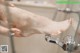 A woman is washing her feet in the shower.