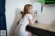 A woman sitting on a stool in front of a mirror.