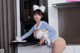 A woman in a bunny costume is posing in the kitchen.