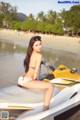 A woman in a bikini sitting on a jet ski.