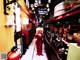 A woman in a red dress walking through a store.