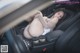 A woman is sitting in the back seat of a car.