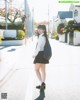 A woman in a school uniform is walking down the street.