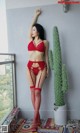 a woman in a red lingerie posing next to a cactus