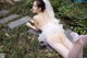 A woman in a wedding dress laying on the ground.