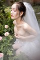 A woman in a wedding dress sitting in a garden.