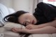 A woman laying on a bed with her head on a pillow.