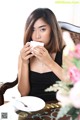 A woman sitting at a table with a cup of coffee.