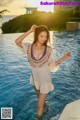 A woman in a white dress standing in a pool.