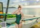 A woman in a green swimsuit standing next to a boat.