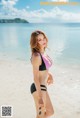 A woman in a bikini standing on a beach.