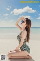 A woman in a bathing suit sitting on the beach.