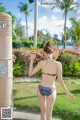 A woman in a bikini standing in front of a shower.