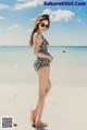 A woman in a bathing suit standing on a beach.