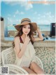 A woman sitting on a white chair wearing a straw hat.