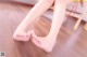 A woman sitting on a chair with her bare feet on the floor.