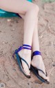 A close up of a woman's legs wearing purple sandals.