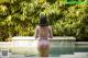 A woman in a pink bodysuit standing in a pool.