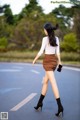 A woman walking down the street with a cell phone in her hand.