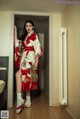 A woman in a red and white kimono standing in a room.