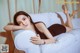 A woman laying on top of a white couch.