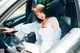 A woman sitting in the driver's seat of a car.