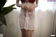 A woman in a white dress with red roses on it.