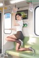 A woman sitting on a green bench on a subway train.