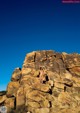 A woman standing on top of a large rock formation.