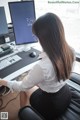 A woman sitting at a desk in front of a computer.