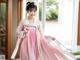 A young girl wearing a pink and green hanbok.