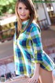 A woman in a plaid shirt posing for a picture.