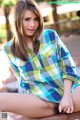 A young woman sitting on top of a wooden bench.