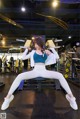 A woman sitting on a bench in a gym.