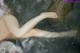 A naked woman laying in a body of water.