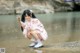 A woman in a pink kimono is sitting in the water.