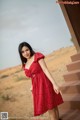 A woman in a red polka dot dress posing for a picture.