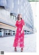 A woman in a red dress is walking down the street.