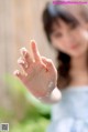 A little girl holding her hand up in the air.