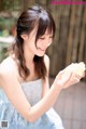 A woman in a blue dress holding a piece of cake.