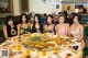 A group of women sitting at a table with plates of food.