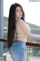 A woman with long black hair standing on a balcony.