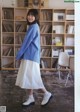 A woman standing in front of a bookshelf in a library.